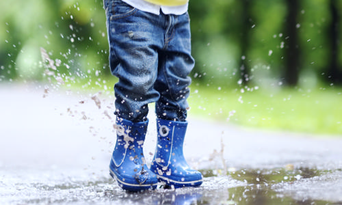 Barn hopper i vandpyt